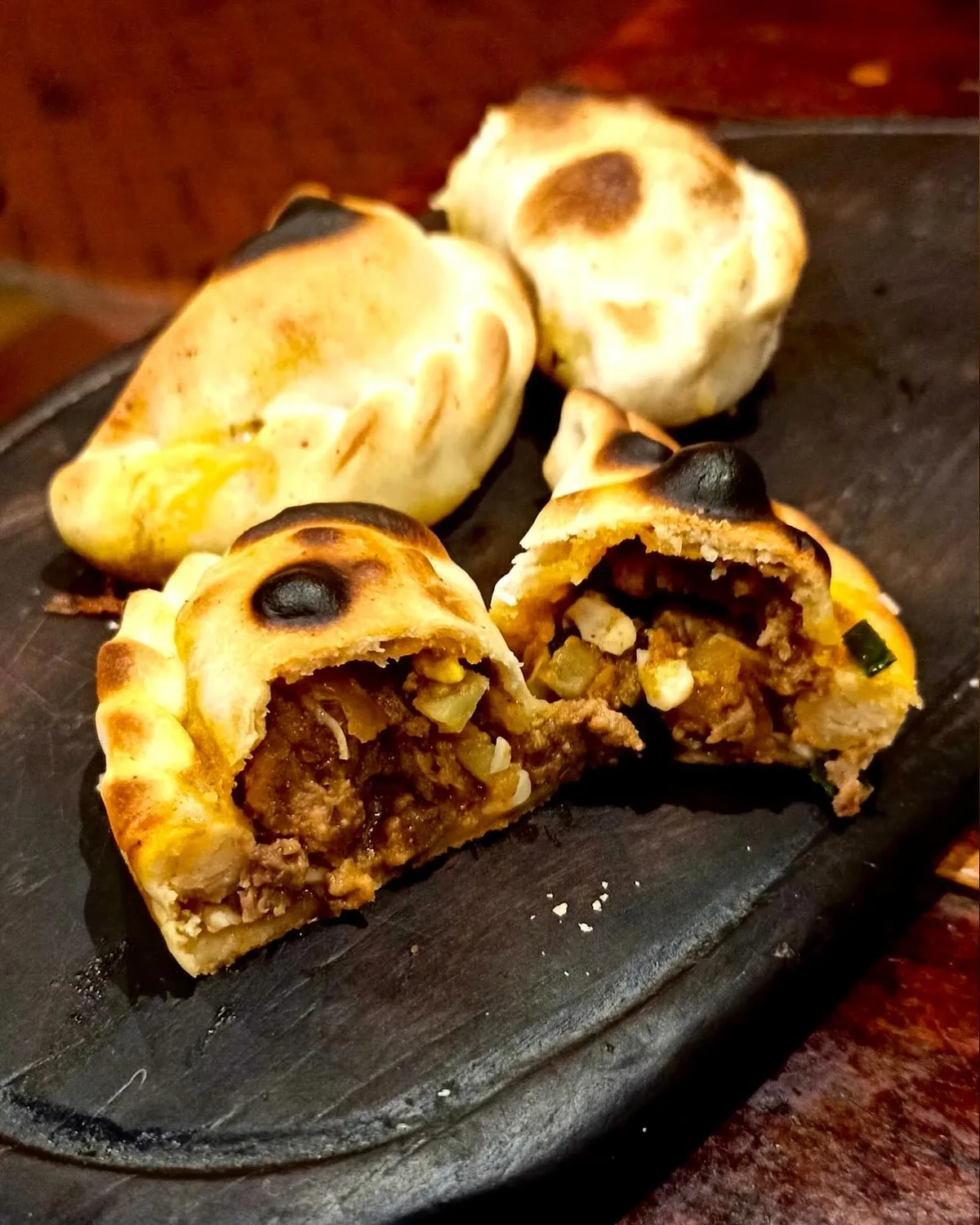 Empanada salteña partida al medio mostrando el relleno de carne cortada a cuchillo
