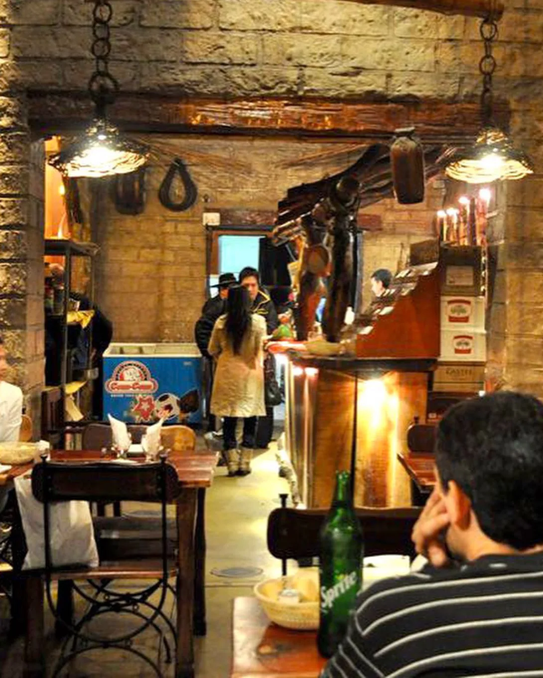 Salón interior de Doña Salta con paredes de piedra y lámparas colgantes